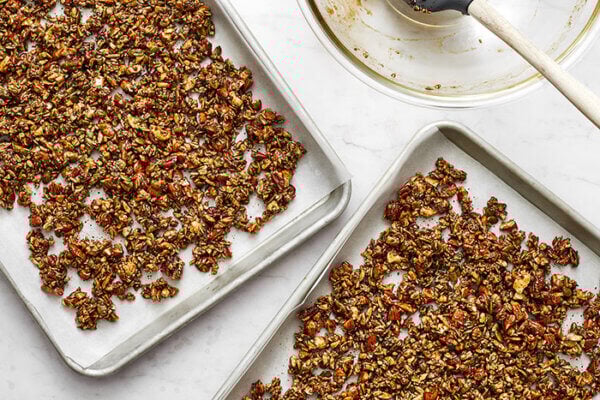 Chai spiced granola on two baking sheets