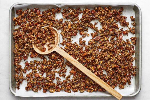 Baked chai spiced granola on a sheet pan with a spoon
