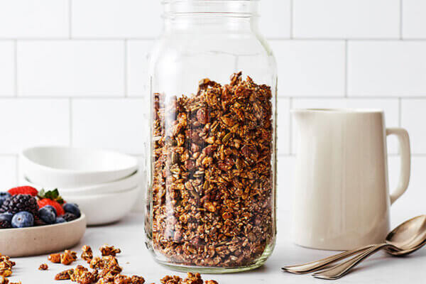 Chai spiced granola in a jar next to fruit