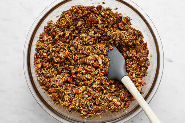 Stirring chai spiced granola in a bowl