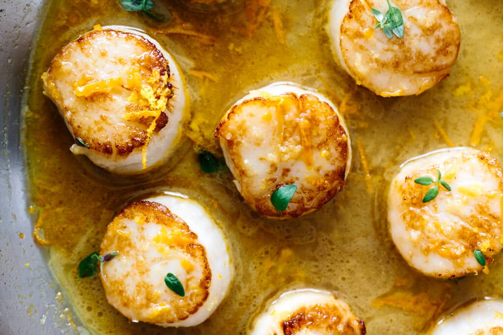 Close up of scallops in a pan.