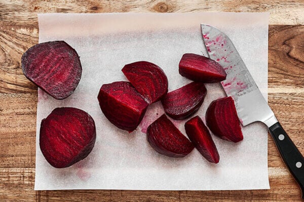 Sliced roasted beets next to a knife