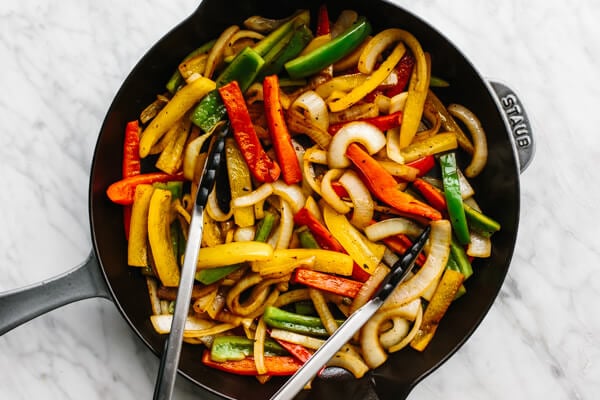 Sauteing veggies in a skillet for steak fajitas