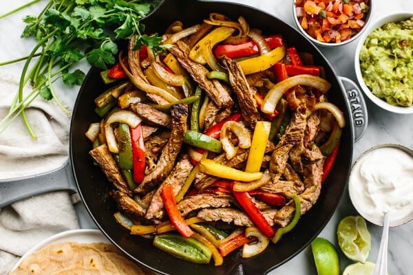 A skillet loaded with steak fajitas