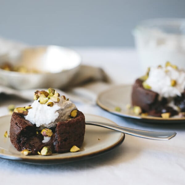 (gluten-free, dairy-free, paleo) Molten Chocolate Cake. This warm, molten and gooey chocolate cake is divine with coconut whipped cream and pistachios.
