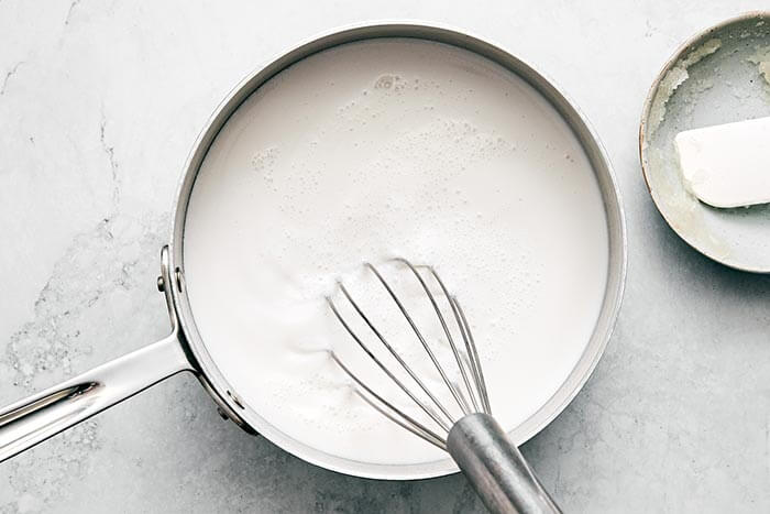 Whisking coconut milk in a pot.
