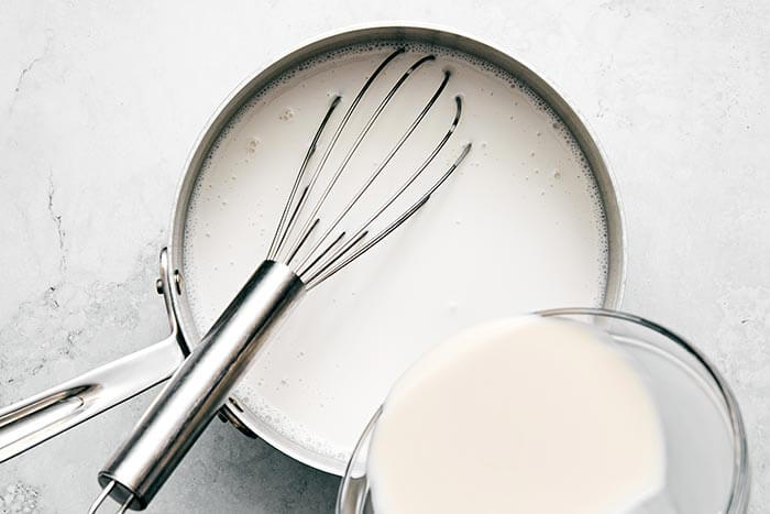 Whisking together coconut yogurt in a pot.