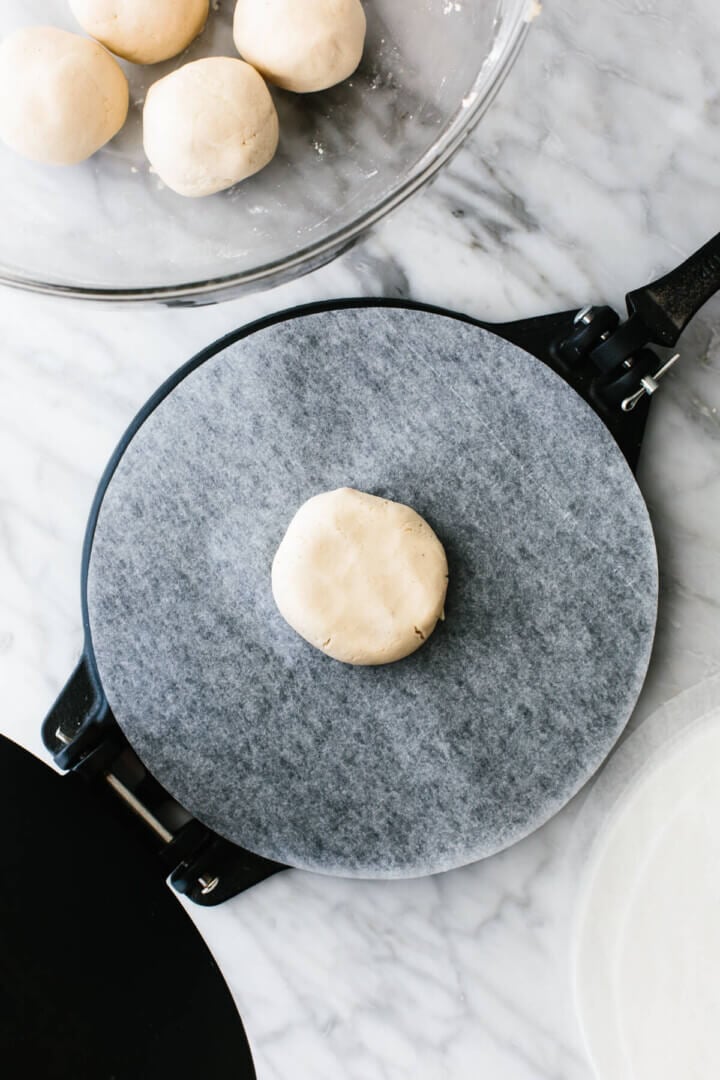 A ball of cassava flour tortilla dough on a tortilla press