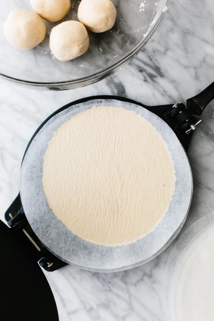 Flattened cassava flour tortilla on a tortilla press