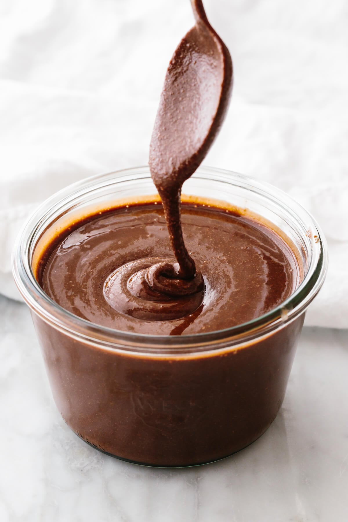 Homemade Nutella in a jar with a spoon.
