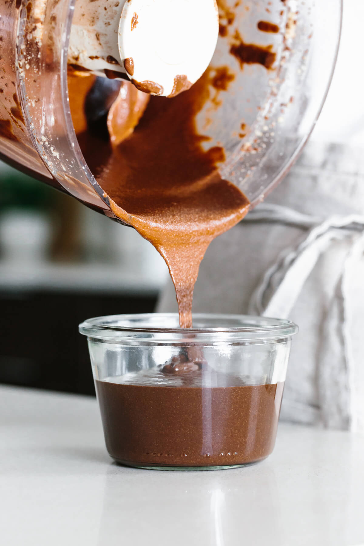 Pouring homemade Nutella into a jar.