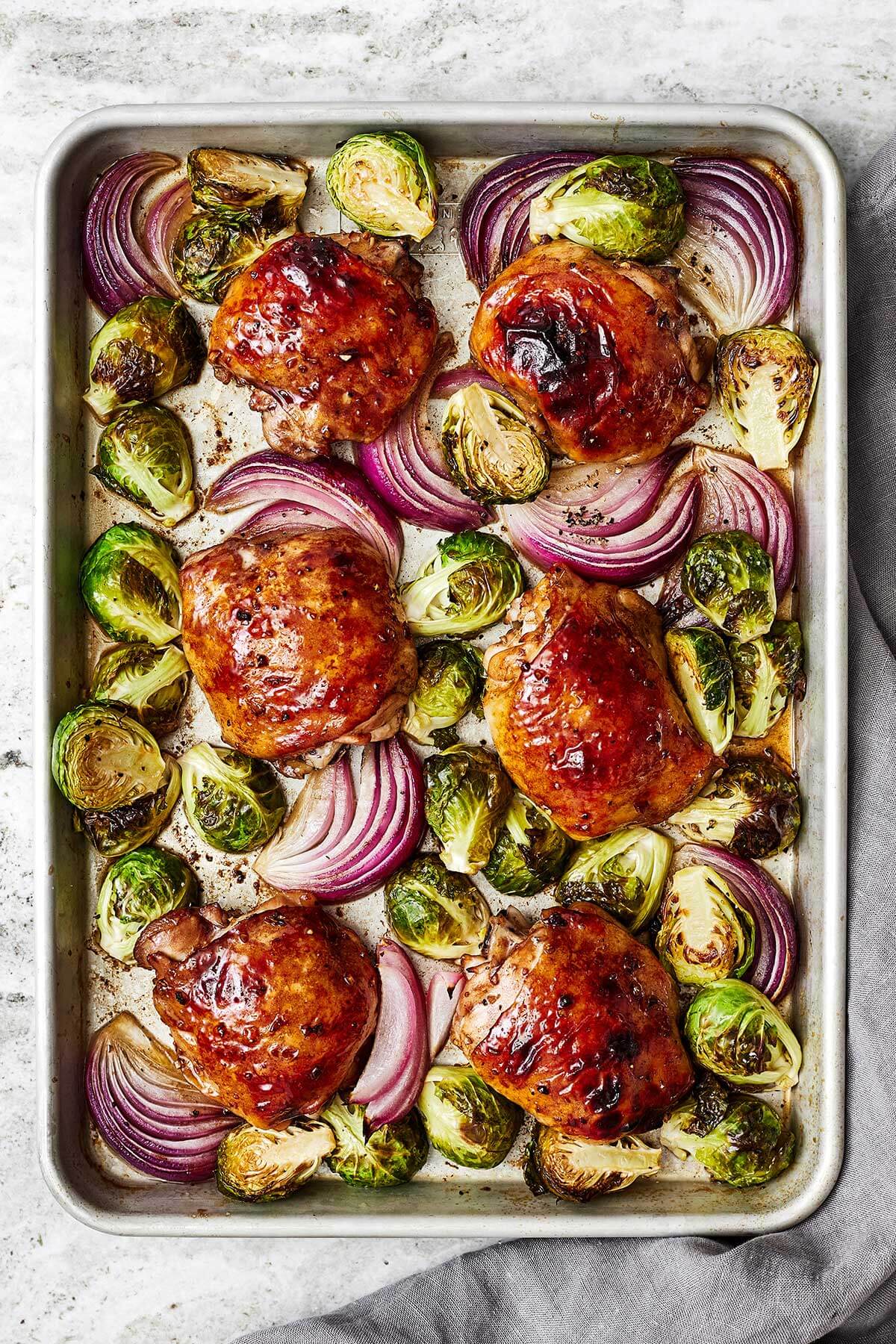 Dinner just got a whole lot better with this easy sheet pan recipe loaded with balsamic chicken, Brussels sprouts, and red onions! Balsamic chicken and Brussels sprouts on a sheet pan
