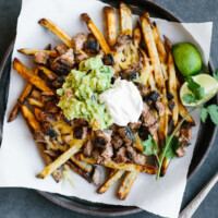 Fries topped with carne asada, cheddar cheese, guacamole and sour cream.