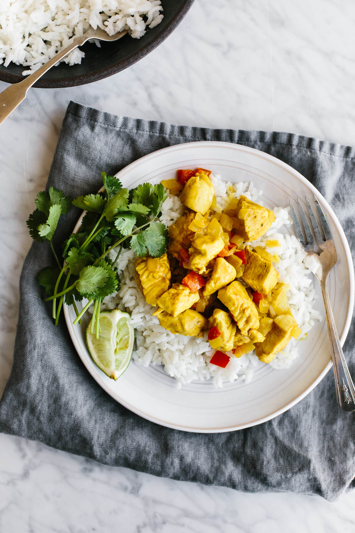 Coconut curry chicken is an easy, healthy, one-pan, weeknight dinner recipe that's packed with flavor! A plate of coconut curry chicken on rice.