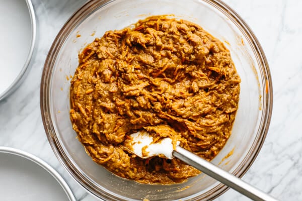 Carrot cake ingredients being mixed in a bowl.