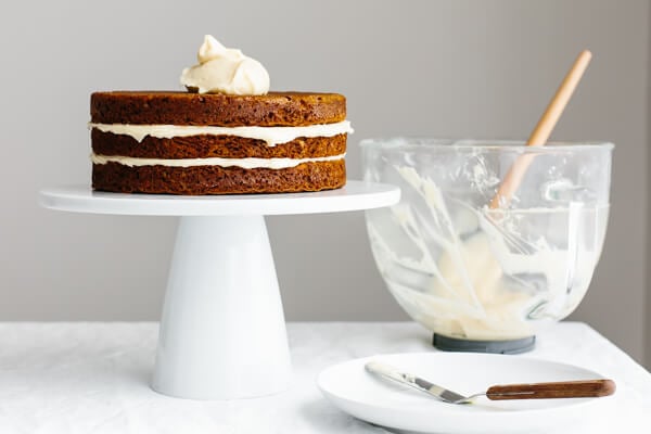 Adding cream cheese frosting to carrot cake.