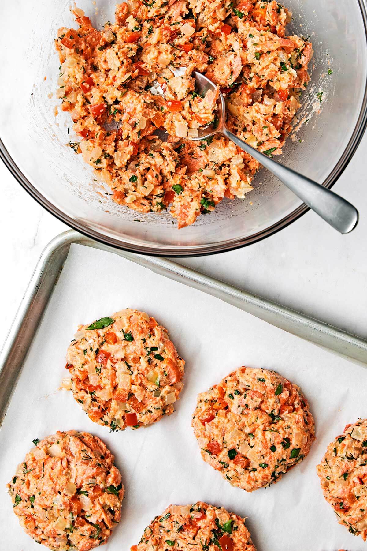 Forming salmon patties on a baking sheet.