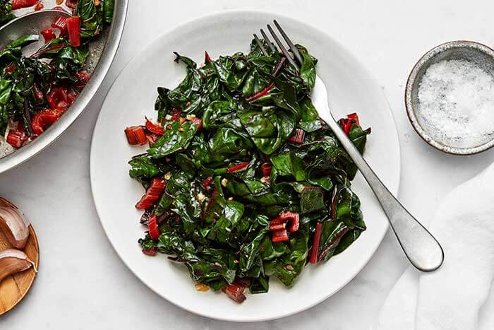 Sauteed swiss chard on a plate with a fork.