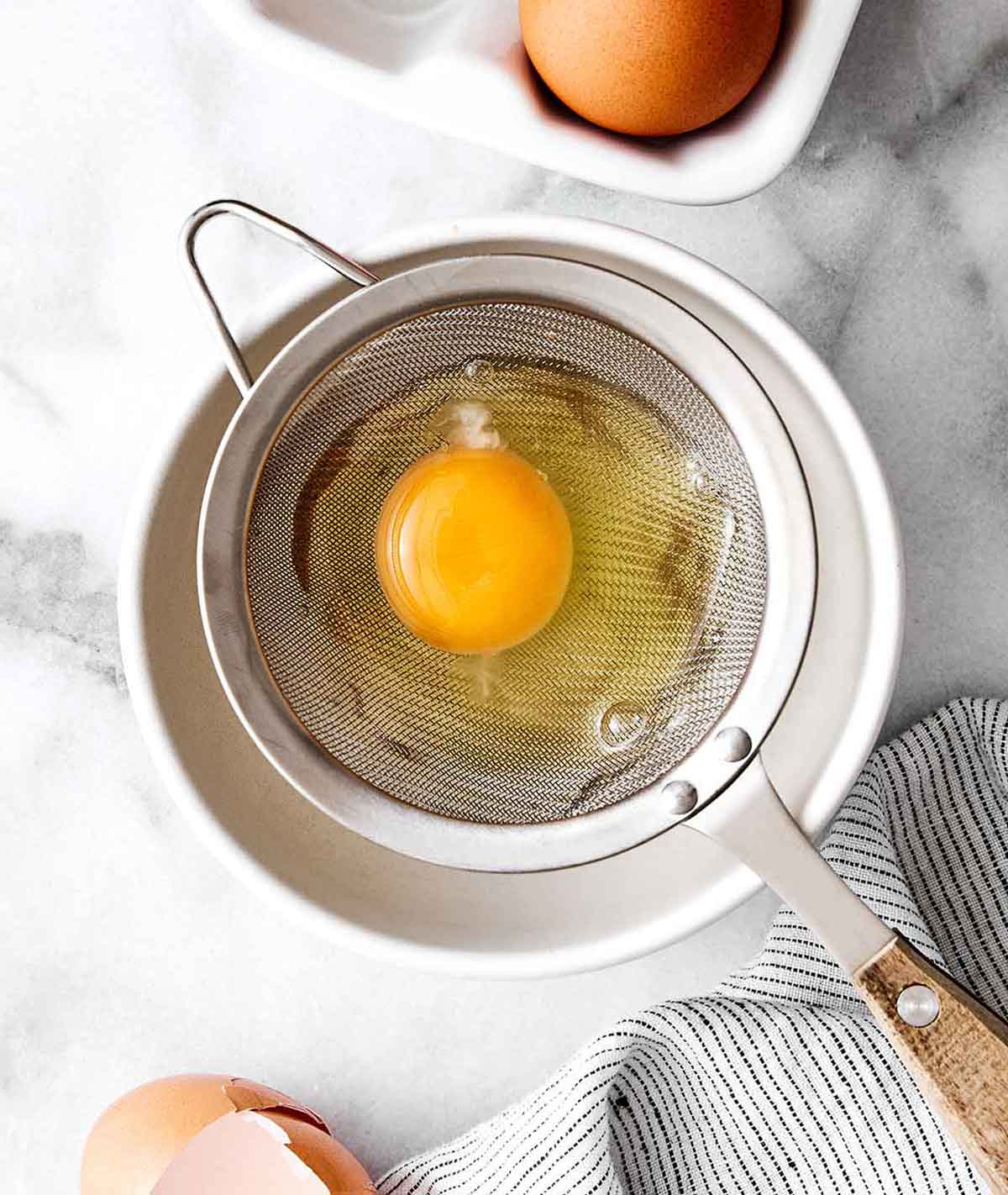 Learn how to make perfect poached eggs every time with this easy method! It'll be a delicious addition to a healthy breakfast. Step one of poached eggs: Crack the egg.