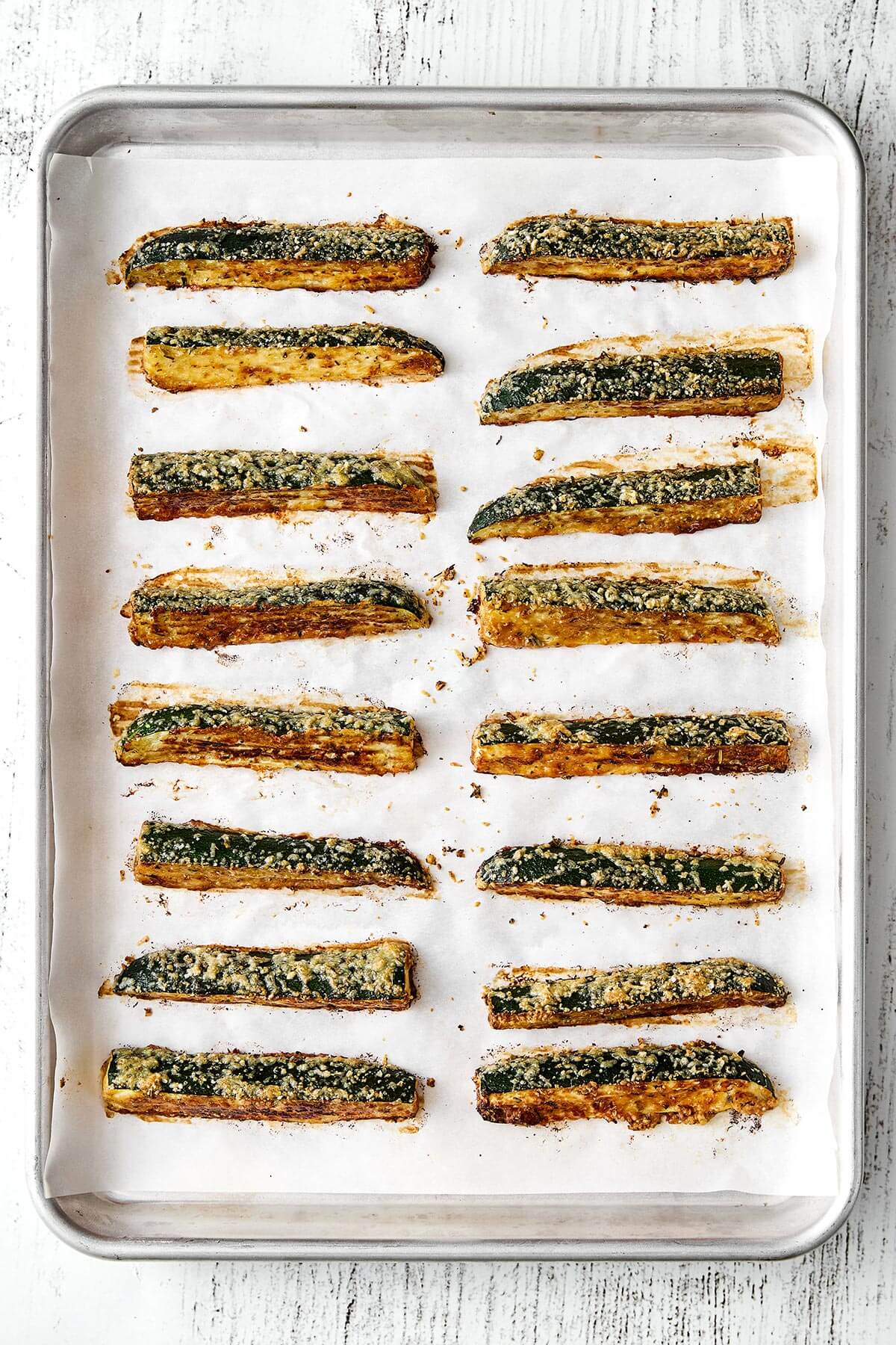 Baked zucchini fries on a sheet pan.