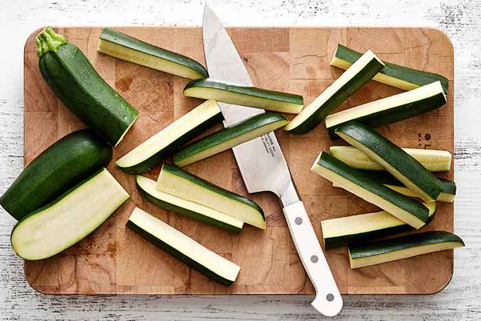 Sliced zucchini on a wooden board.
