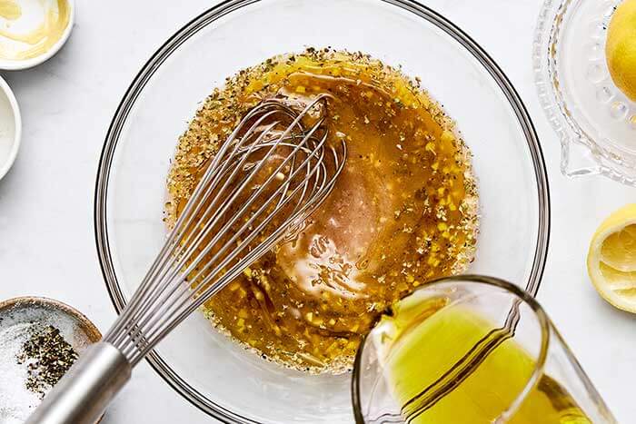 Making Greek salad dressing in a bowl.