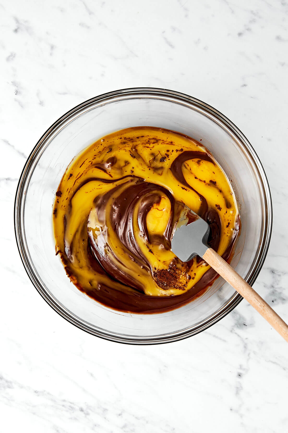 This flourless chocolate cake is a deliciously elegant yet easy chocolate dessert that’s sure to impress guests. Mixing egg yolks and chocolate in a bowl.
