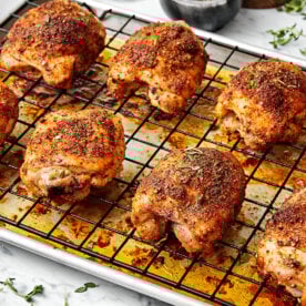 Baked chicken thighs on a sheet pan.