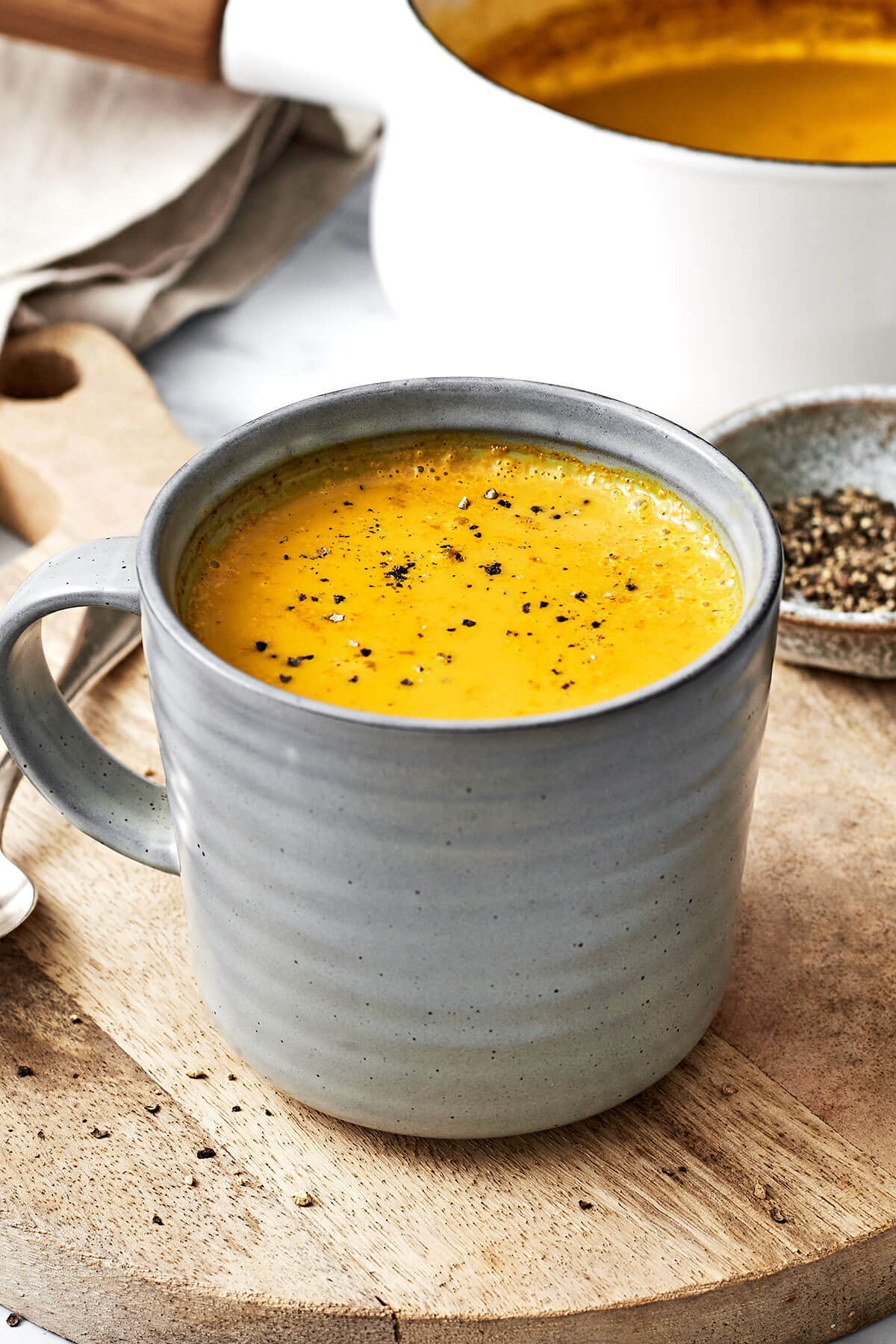 A mug of golden milk on a wooden board