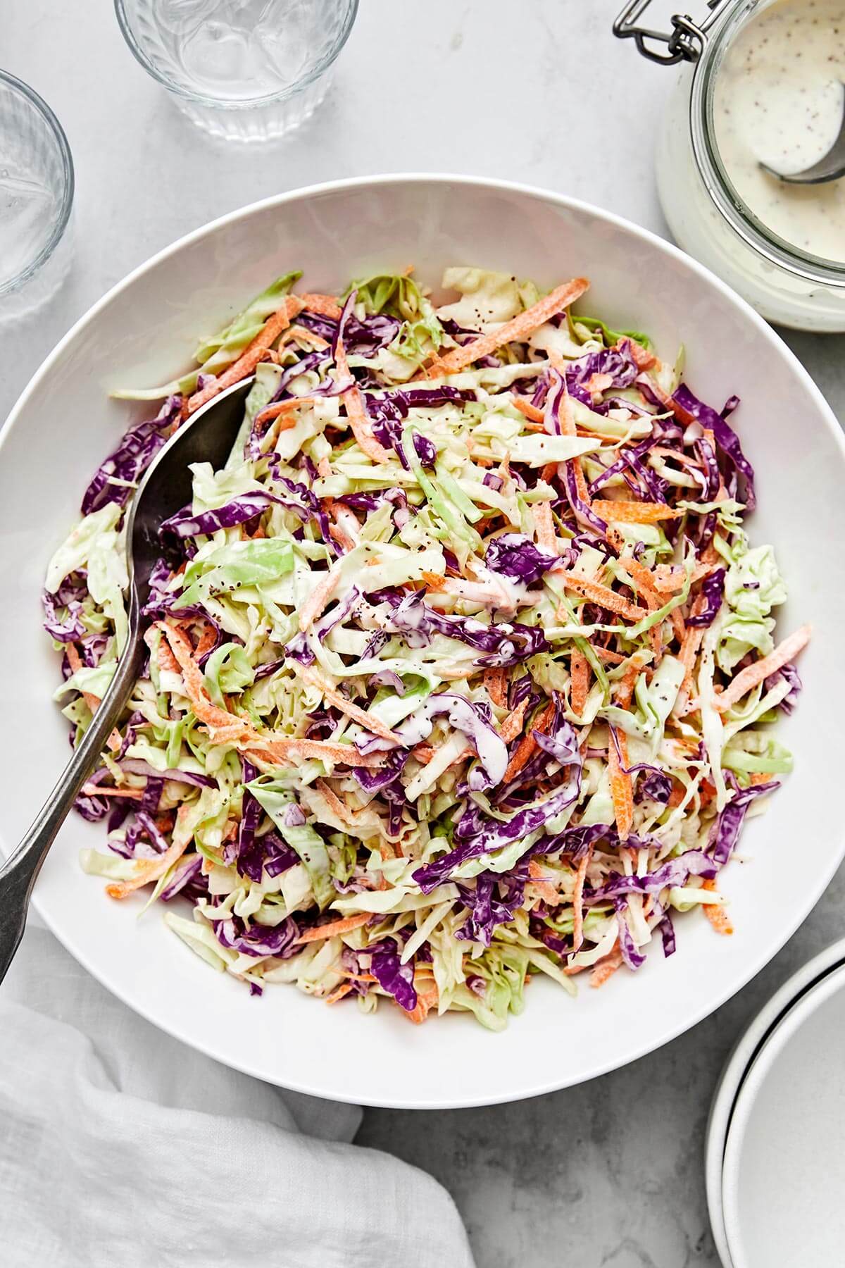 This easy coleslaw recipe is perfect for summer BBQ's and potlucks, whether it's served as a side dish or layered in pulled pork sliders! A bowl of creamy coleslaw.
