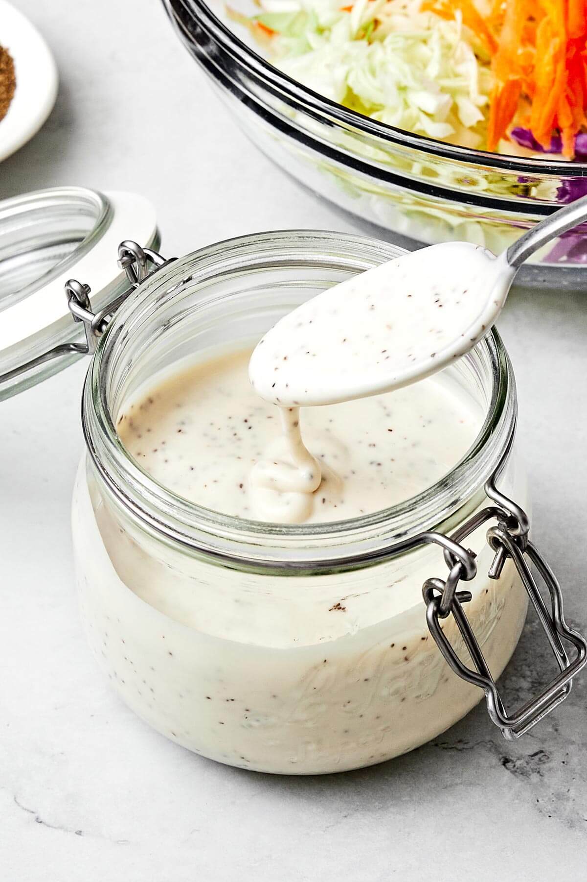 A homemade coleslaw dressing doesn’t get any better than this — tangy, slightly sweet, and perfectly creamy. A container of coleslaw dressing.
