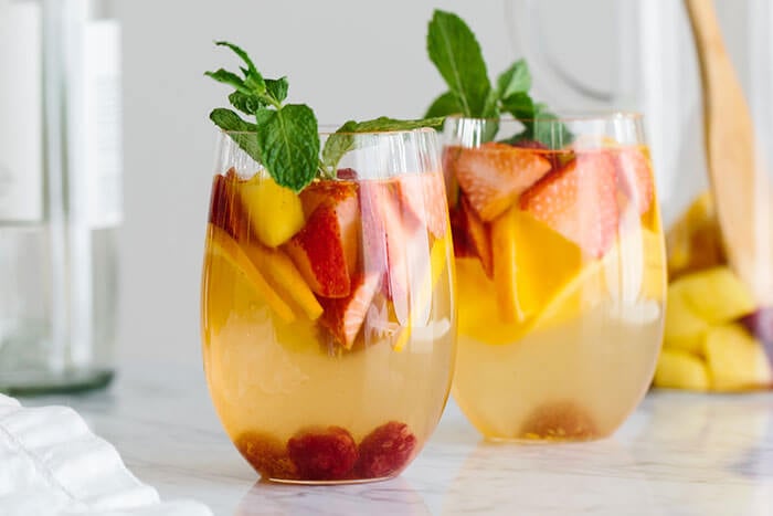 Glasses of white sangria and fruits