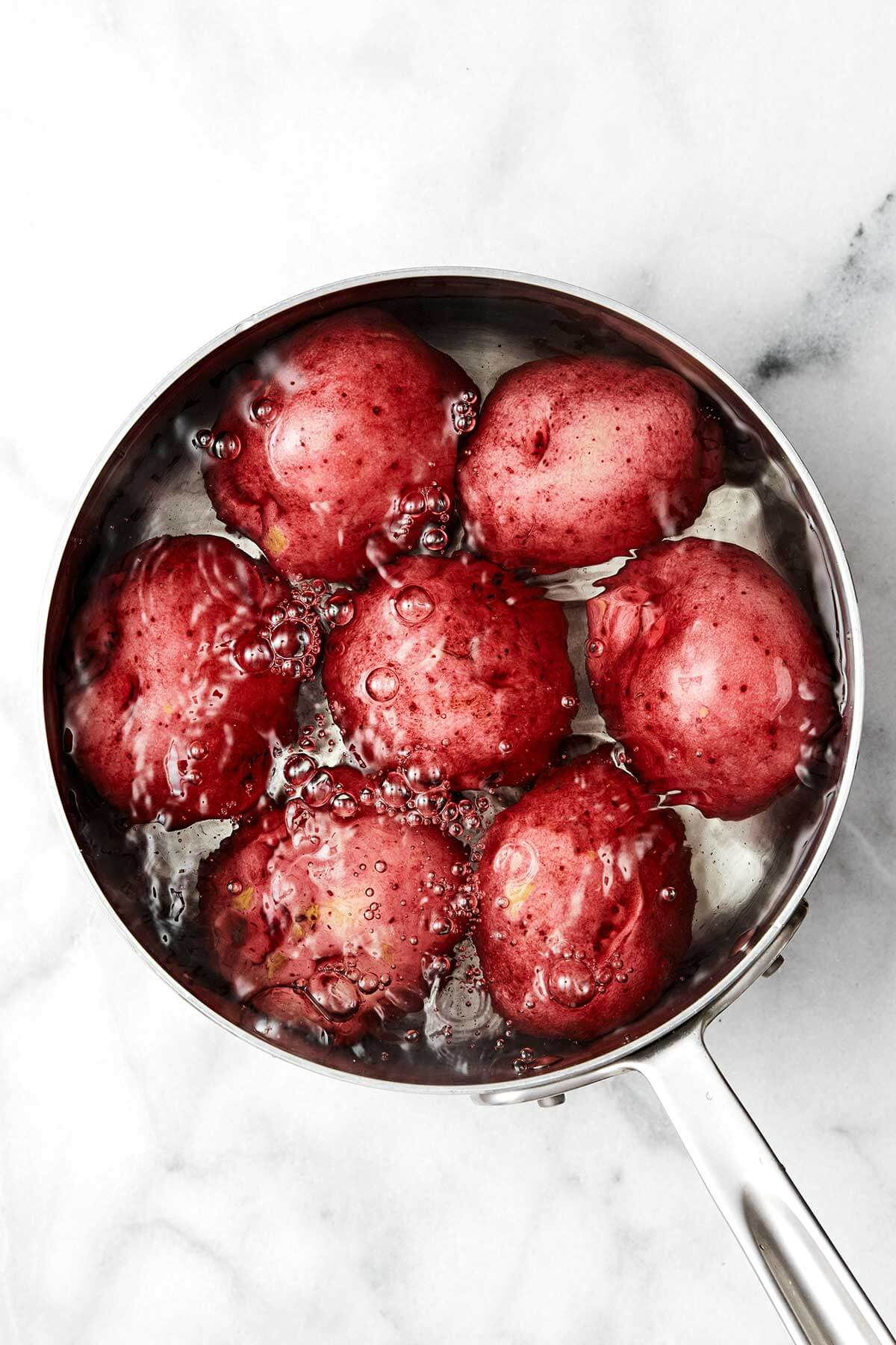 Boiling red potatoes in a pot.