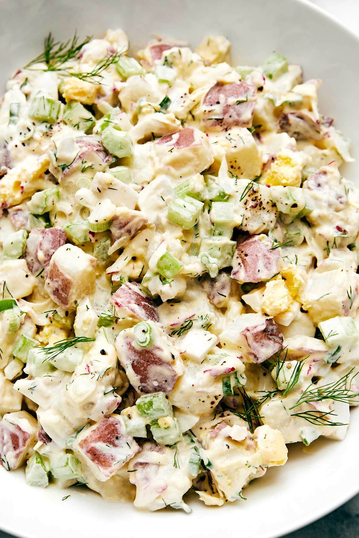 A white bowl of potato salad.
