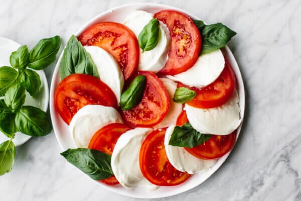 Caprese salad next to basil