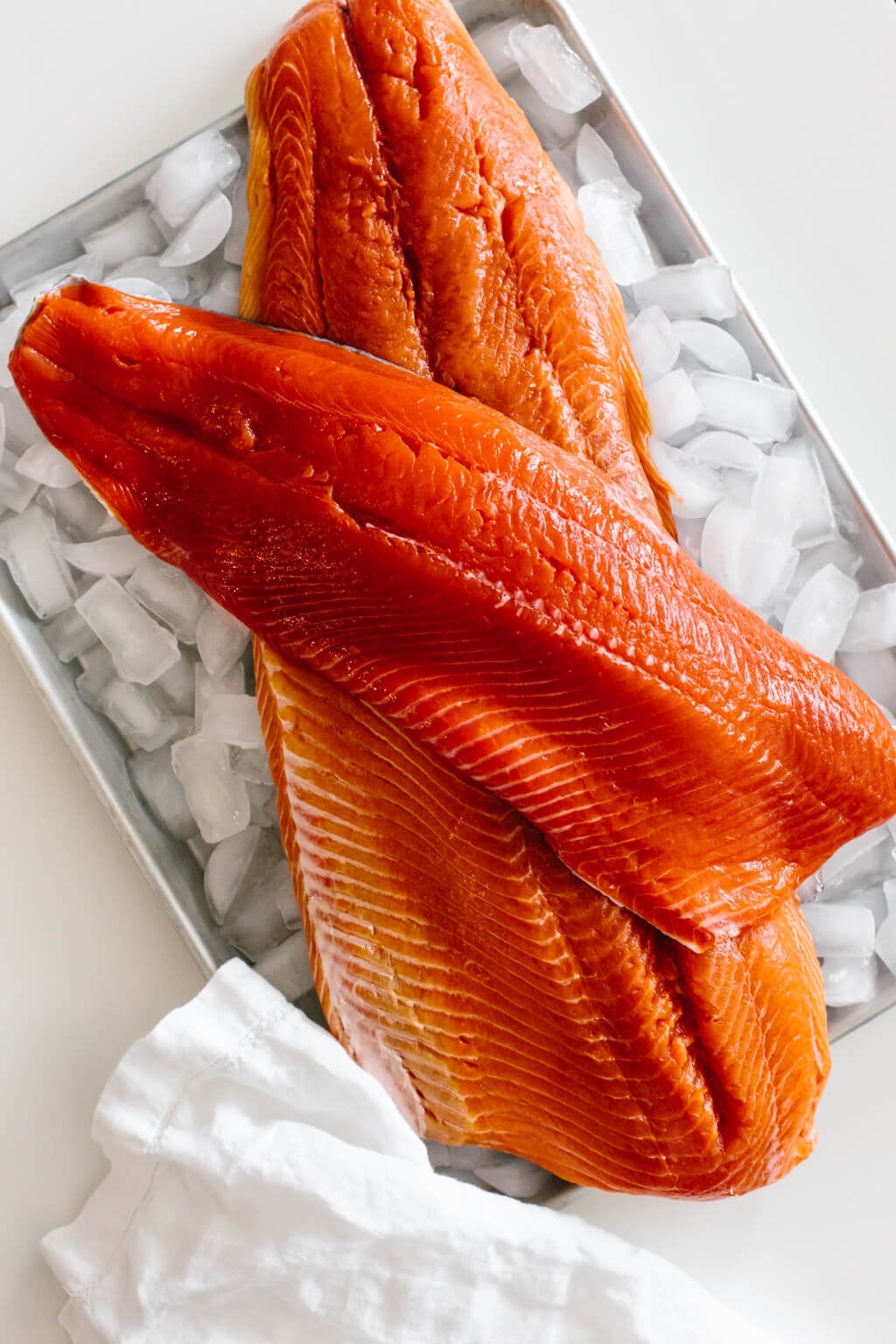 Raw salmon filets on a tray of ice.