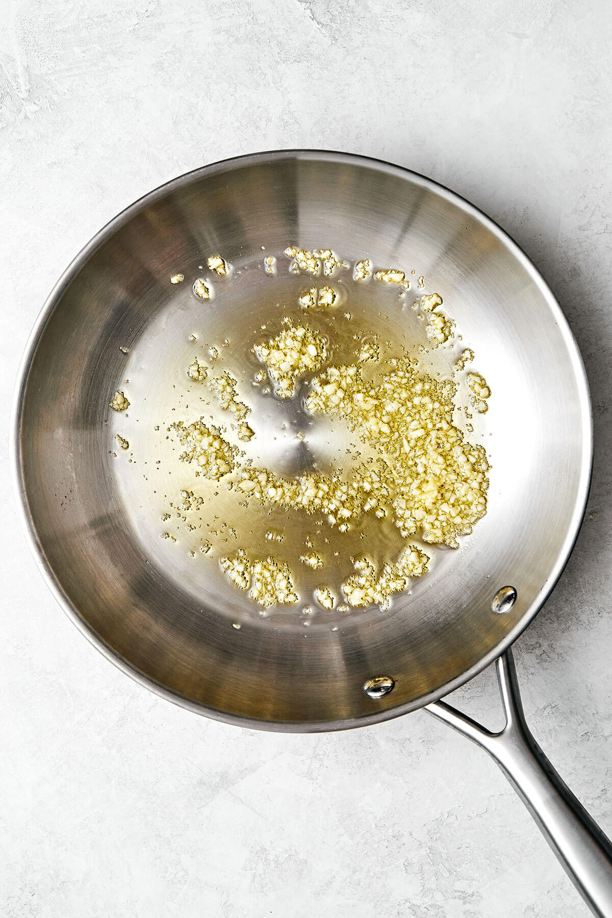 This mashed cauliflower is a fabulous low-carb side dish for weeknight dinners. It's delicious, creamy, flavorful, and quick to make! Cooking garlic in a pan.