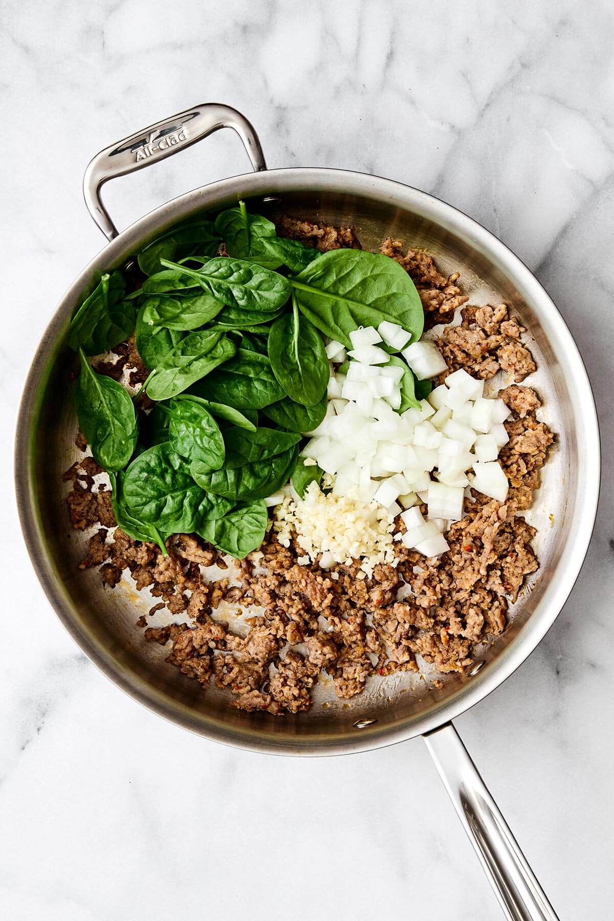 Cooking sausage and veggies in a pan.