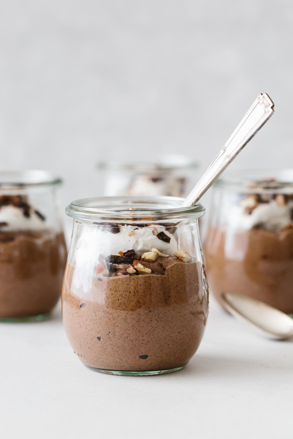 Chocolate chia pudding mousse in small glass jars.