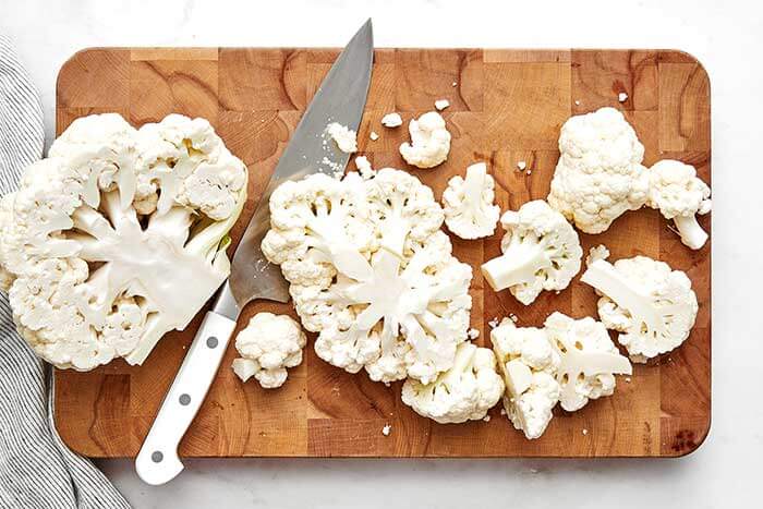 Sliced cauliflower on a chopping board.