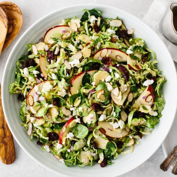 Shaved Brussels sprouts salad in a white serving bowl.