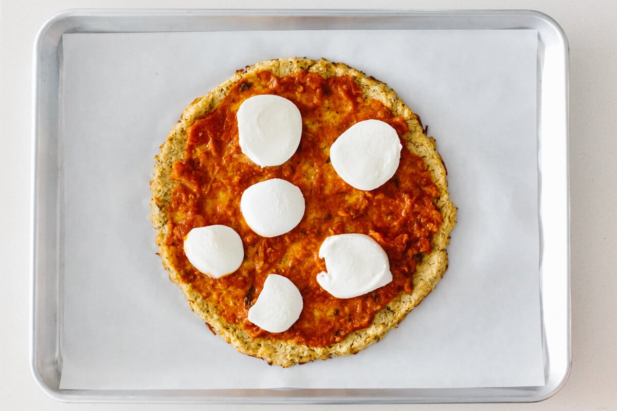 Making cauliflower pizza crust with toppings.