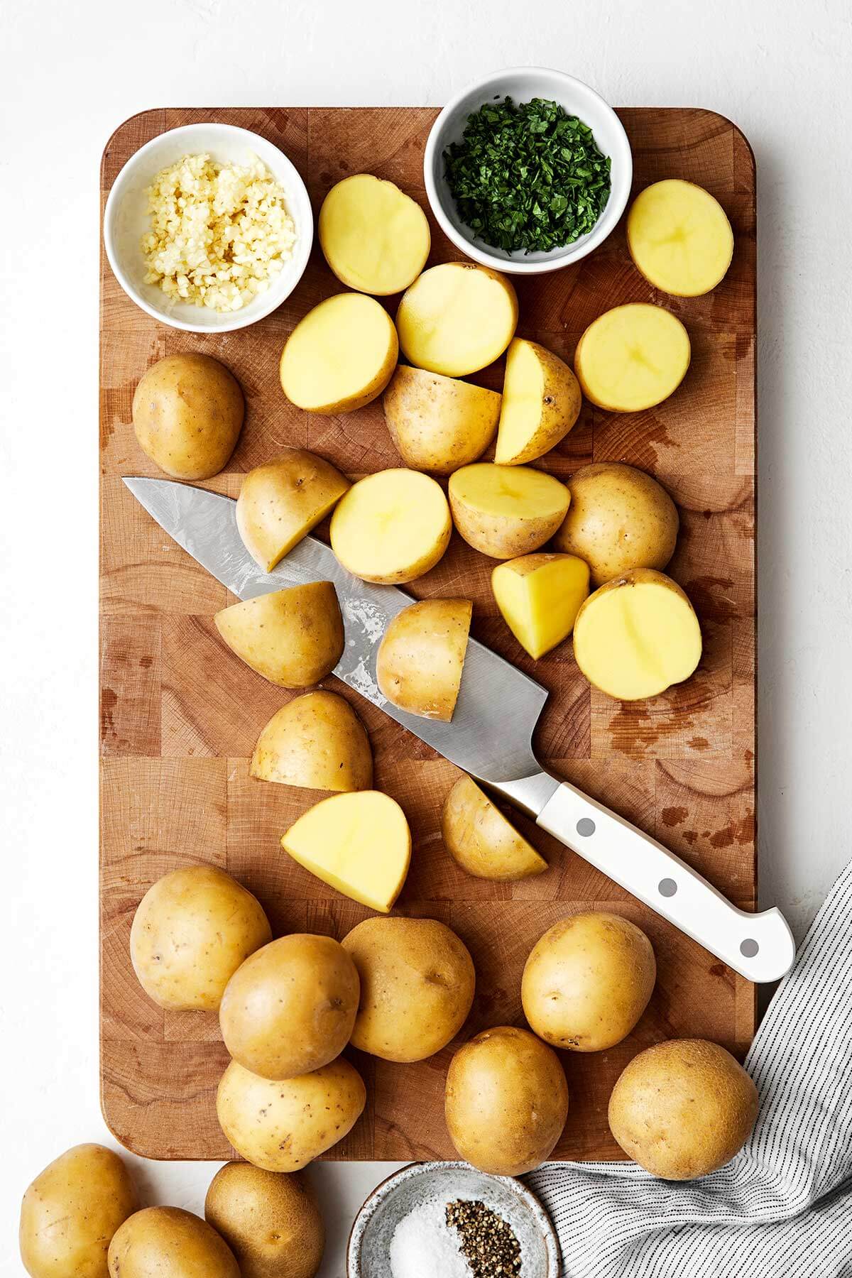 Sliced potatoes on a wooden board.