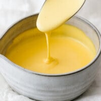 Hollandaise sauce dripping off a spoon.
