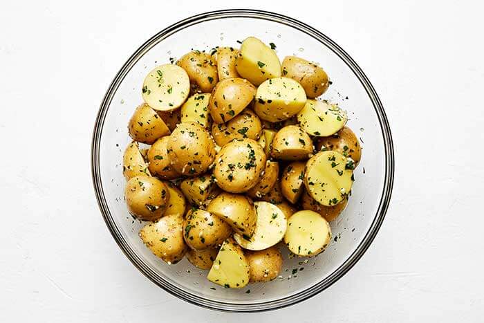 Potatoes with garlic herb seasoning in a bowl.