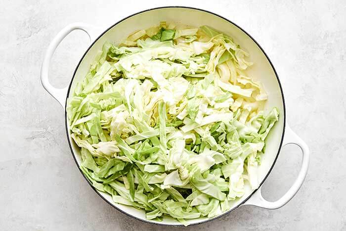 Cooking cabbage and onions in a pan.