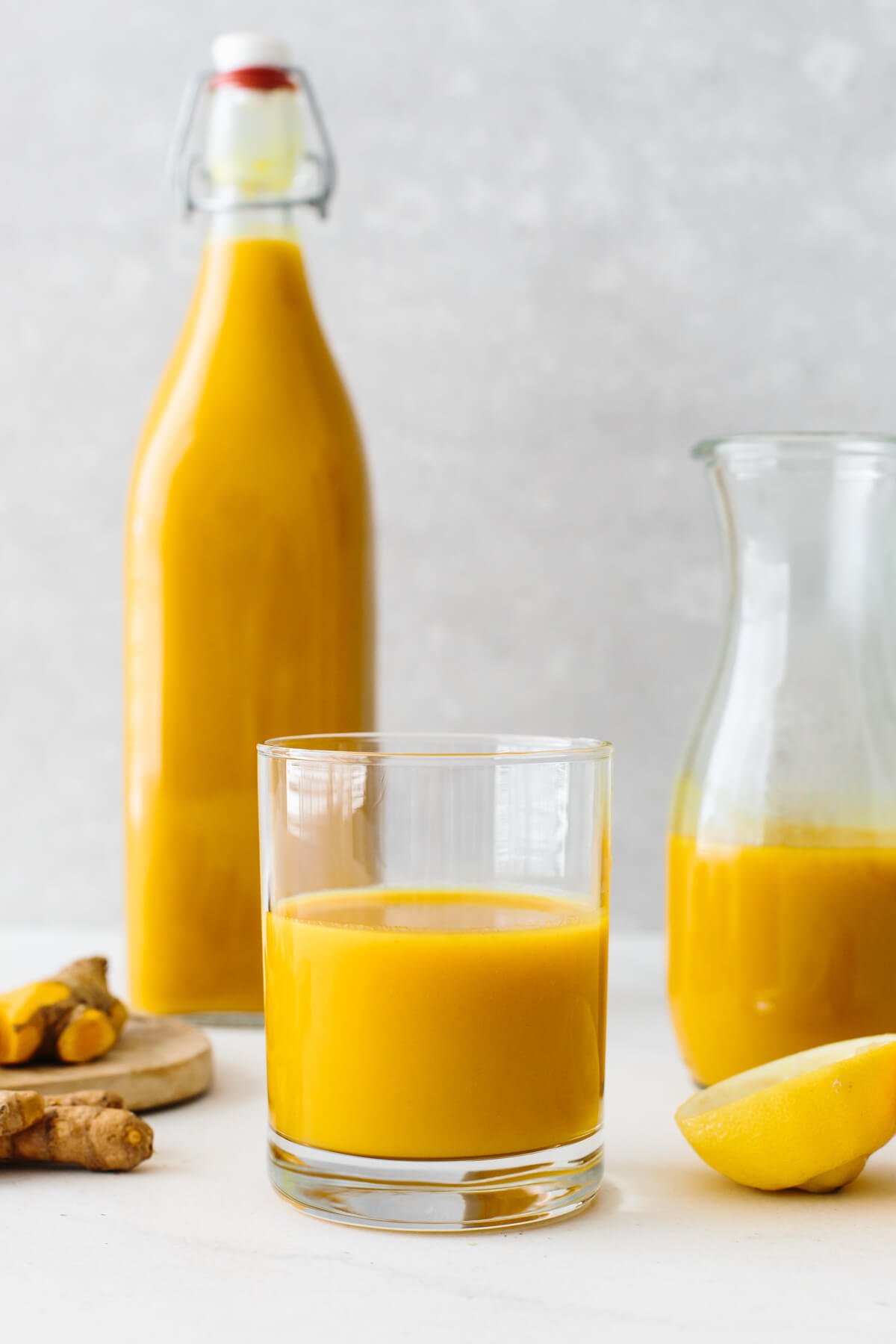 Jamu juice is an Indonesian anti-inflammatory drink that's a blend of fresh turmeric, ginger, lemon, water, and honey. Jamu juice poured into a glass.
