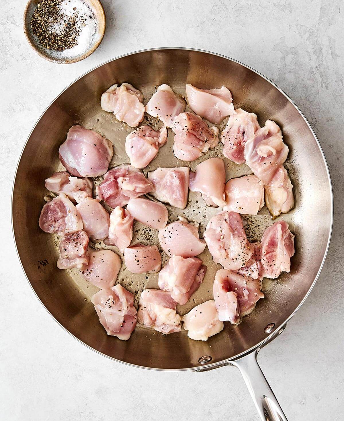 Cooking chicken thighs in a pan.