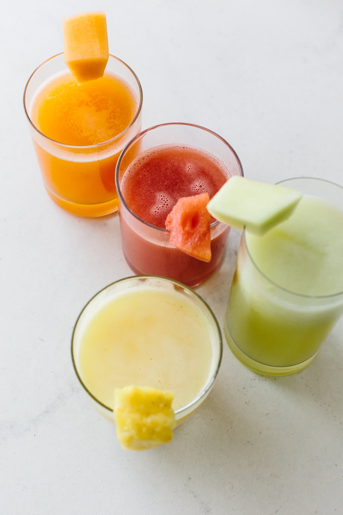 Agua fresca is an easy, refreshing fruit drink made from fruit, water, lime juice and a little sweetener! Various agua fresca drinks on a table.