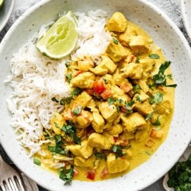 A plate of rice and coconut curry chicken.